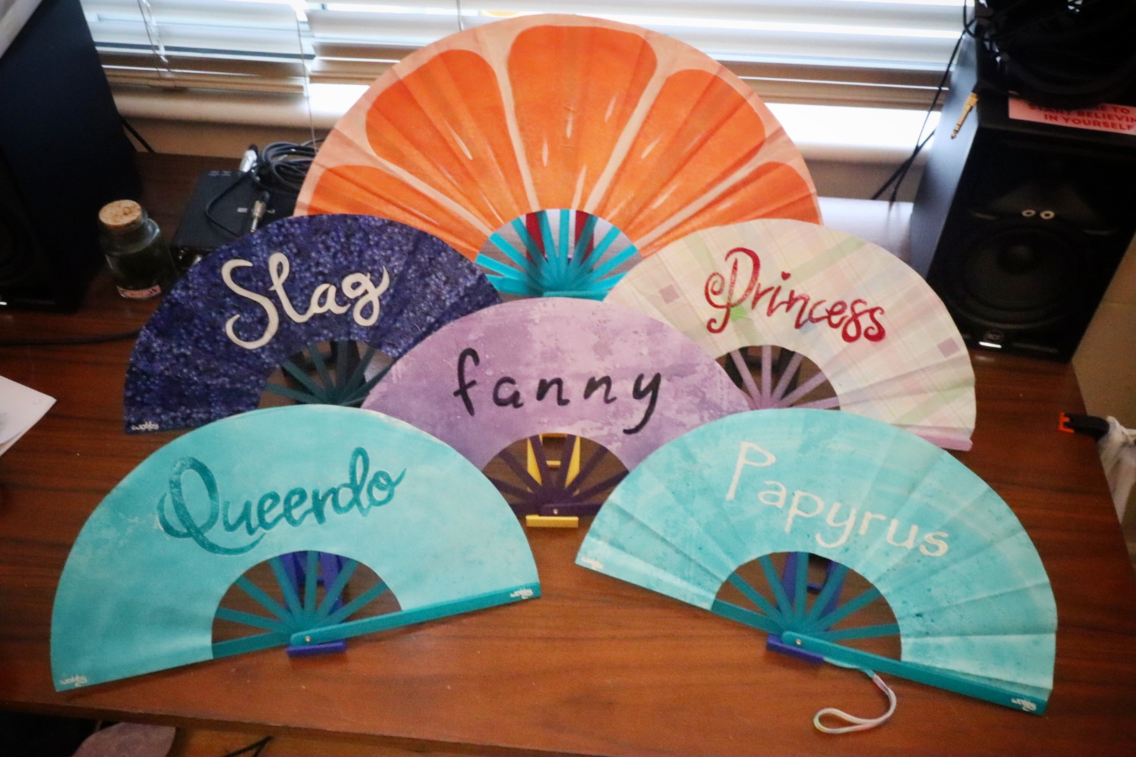 A selection of fans with various words painted on them
